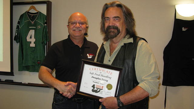 Food Safety 1st, Russell Scott presents Douglas Terry from Melfort Sask. the 9,000th Food Safety 1st certificate!